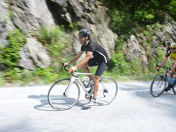 Cyclist riding past rock cliff